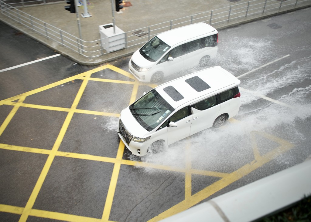 車輛涉水而過，濺起浪花。蘇正謙攝