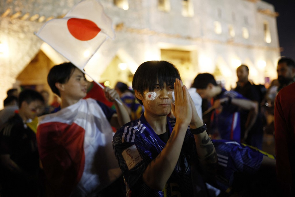 日本球迷在街頭慶祝首次擊敗德國隊。路透