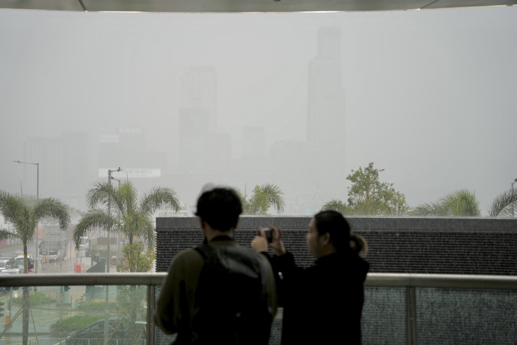 今年首個黃雨，市民舉機拍照。蘇正謙攝