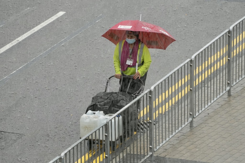 工人冒雨工作。蘇正謙攝