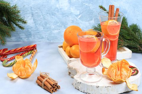 Becher Aperol steht auf dem Tisch eines Straßencafés vor der Kulisse der Berge