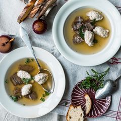 Brätknödelsuppe auf Tellern angerichtet und serviert