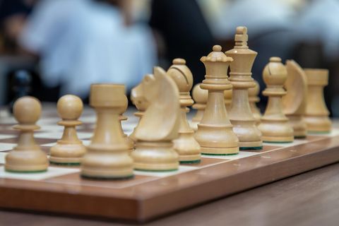 Weiße Figuren stehen auf einem Schach-Brett