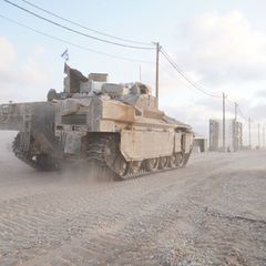 Ein Panzer der Armee von Israel befährt eine staubige Straße in Gaza