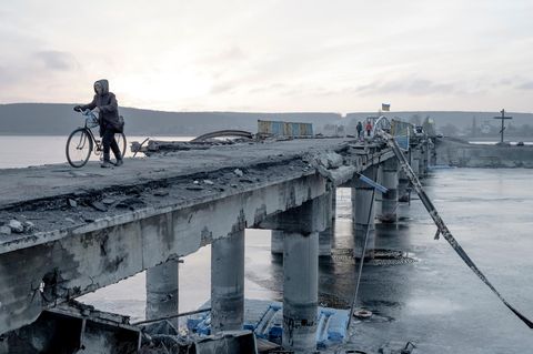 Anwohner überqueren im Januar 2023 eine zerstörte Brücke über den Fluss Siwerskyj Donez in der Region Charkiw (Ukraine)