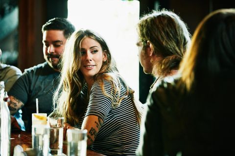 Eine Frau sitzt an einer Bar und flirtet