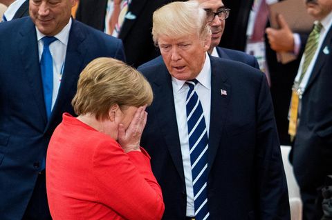 Angela Merkel schlägt die Hände vors Gesicht, während sie mit Donald Trump redet