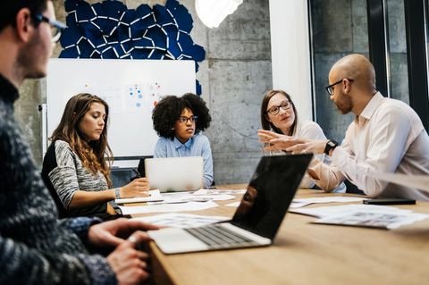 Entscheidungen: Frauen und Männer sitzen an einem Tisch und diskutieren