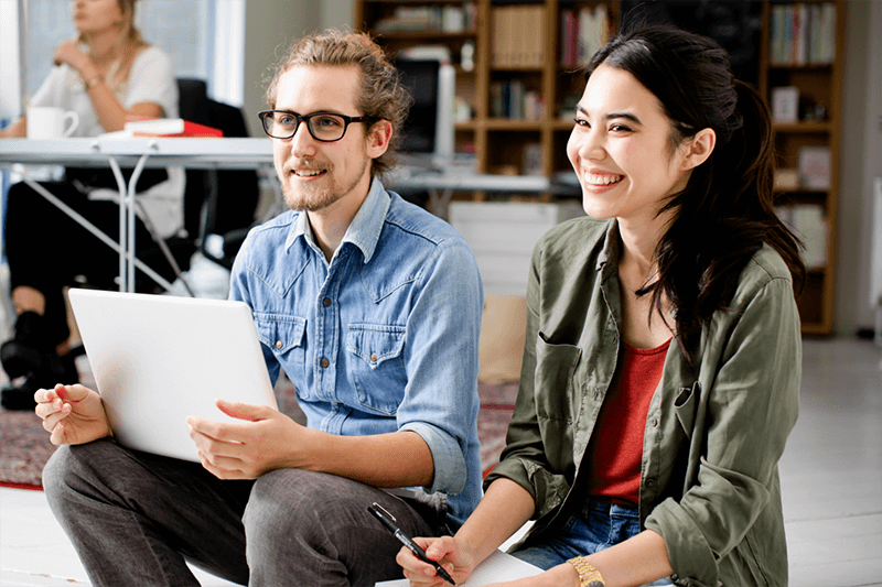 Deux personnes souriantes dans une salle de travail