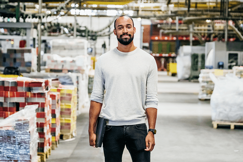 Personne dans une usine portant un ordinateur portable sous le bras