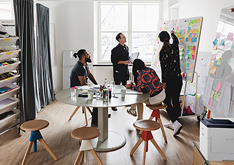 Coworkers looking at a white board covered with sticky notes