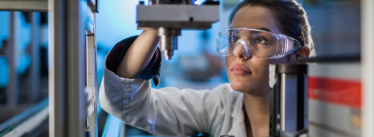 Engineer wearing goggles, working on a 3D printer