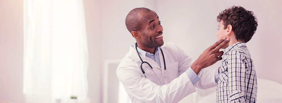 Smiling doctor giving a small child an examination