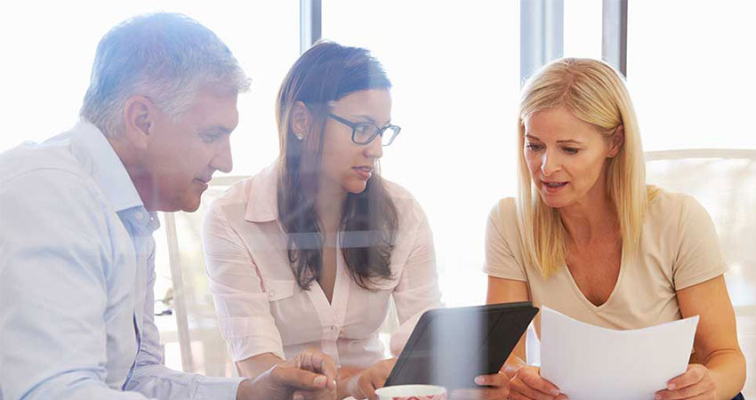 Three co-workers reviewing paperwork