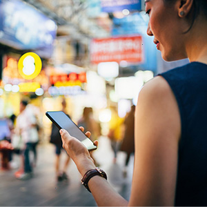 Woman standing holding a phone. 