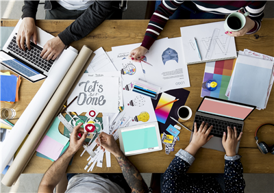 People working around a table covered with print samples