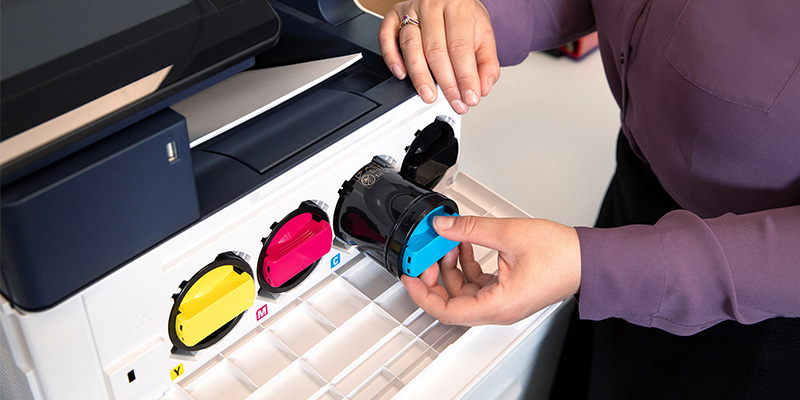 woman loading cyan toner cartridge