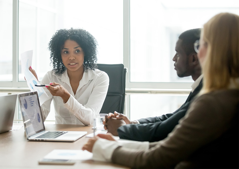 Coworkers in a meeting sitting a table with a laptop 