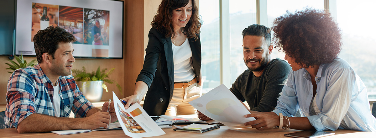 Professionals in a meeting room looking at printed reports