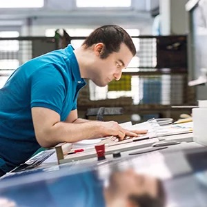 Man in a print shop reviewing print samples