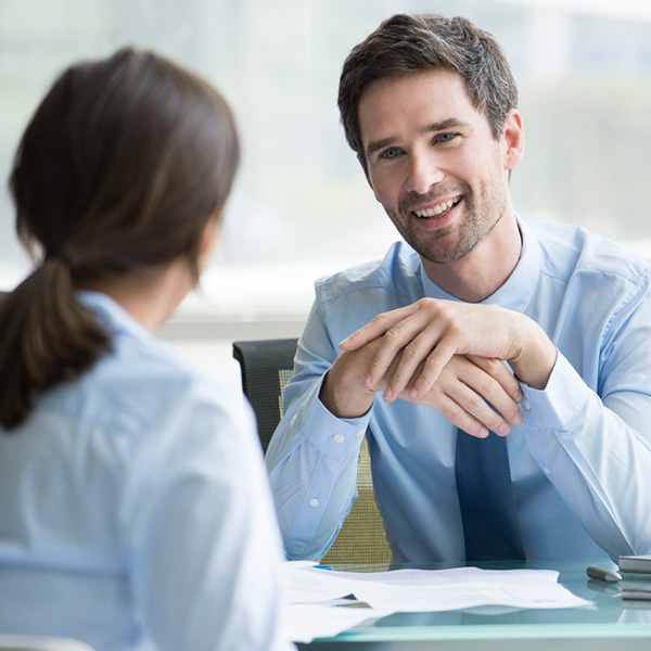 Two people talking over a desk