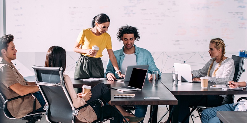 Co-workers working together at a jumble of desks