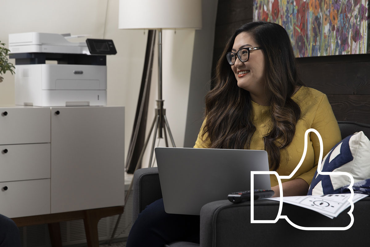 Smiling woman in chair working on her laptop