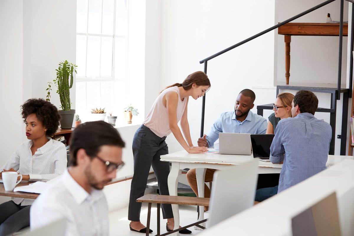 Young professionals in a brightly lit office with white walls and desks