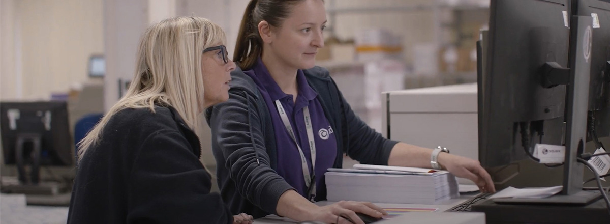 Two women operating a printer