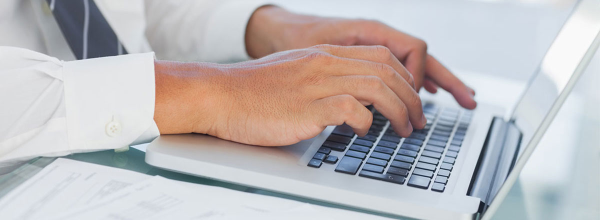 Hands typing on a laptop keyboard