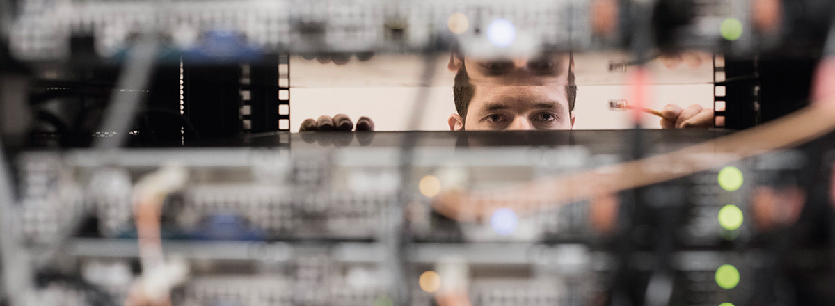 Man looking between the shelves in a secure server room