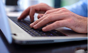 Hands typing on a keyboard