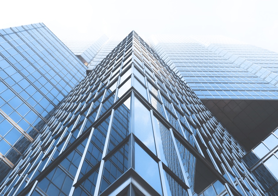 View up the side of a tall, reflective skyscraper