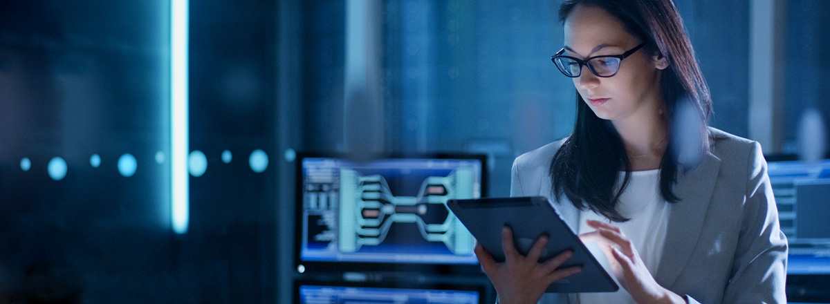 Woman in a server room using a tablet