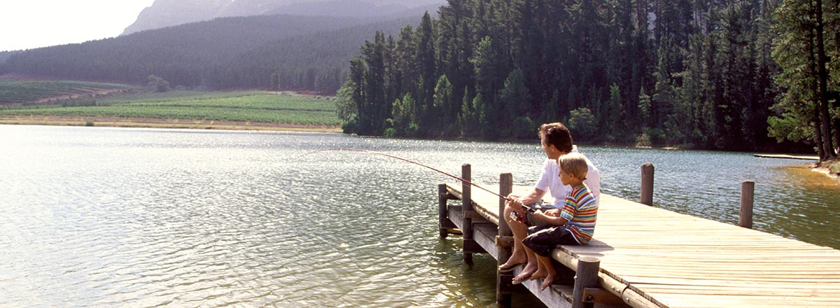 Father and son fishing from a dock