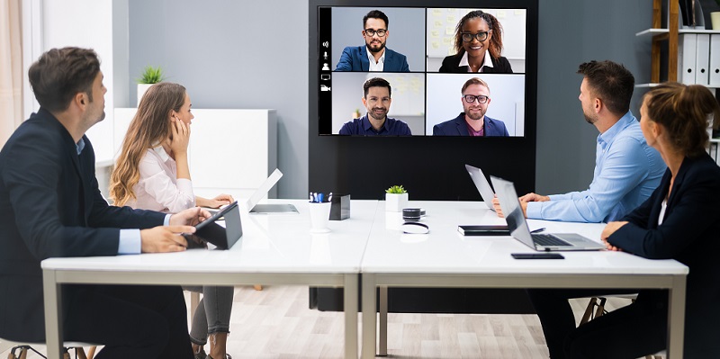 Young people at a table using computers in a meeting