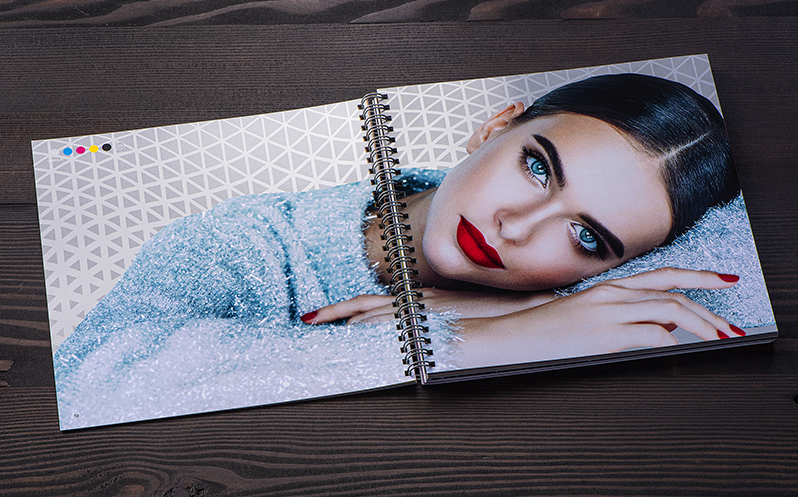 Spiral bound book open to a page with a vivid photo of a woman resting her head on her arms