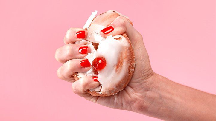 image of a person crushing a doughnut, to represent stress and diet