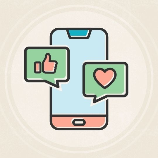 Cellphone with two social media bubbles of thumbs up and heart icon on beige background