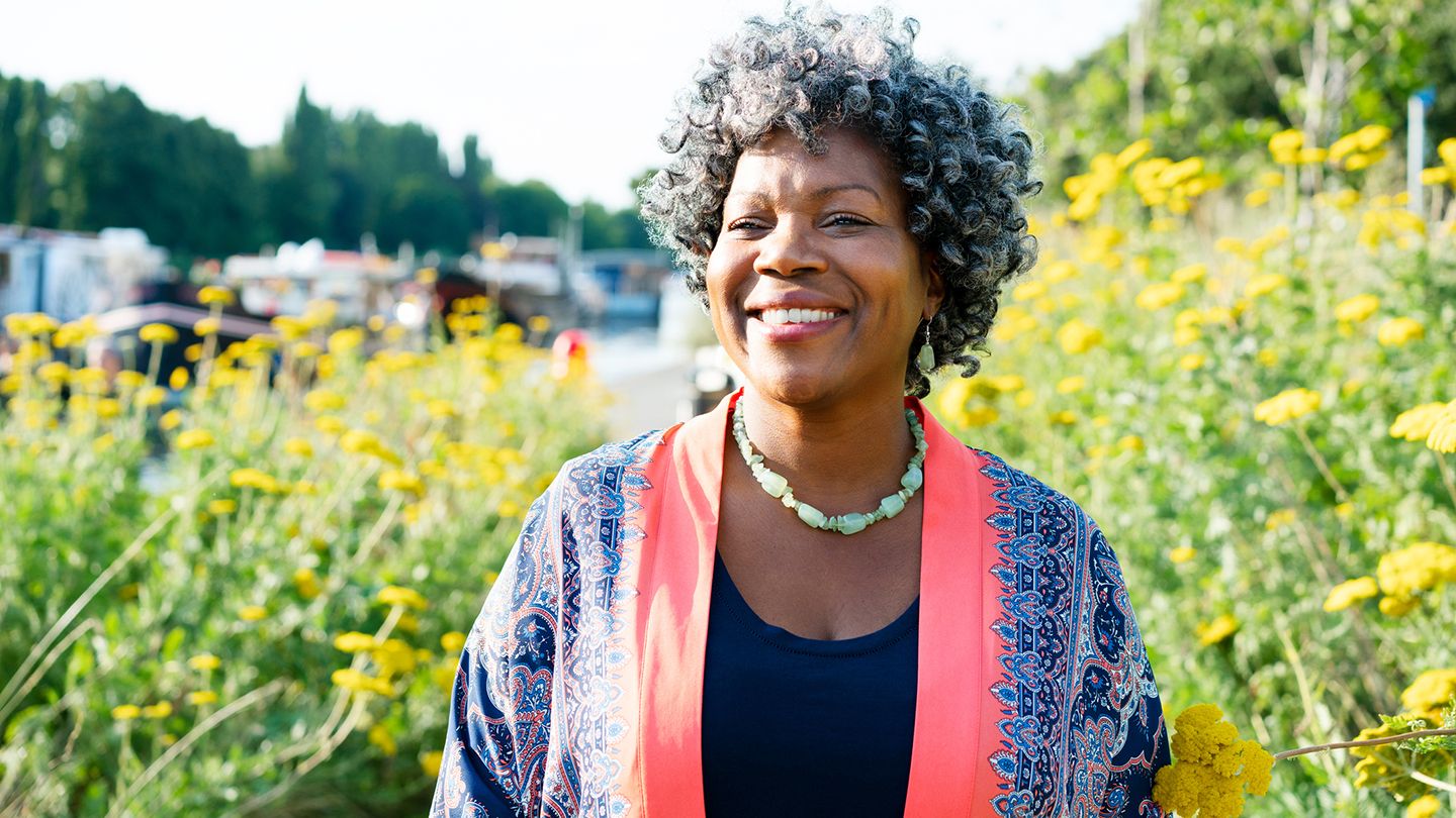 black middle aged woman in garden field of flowers