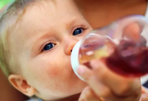 Photo of constipated baby drinking prune juice.