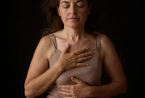 Photo of woman touching chest.