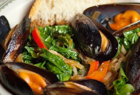 Photo of steamed mussels and greens.