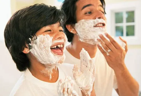 A father teaching his son how to shave.