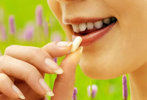 A woman taking an allergy pill.