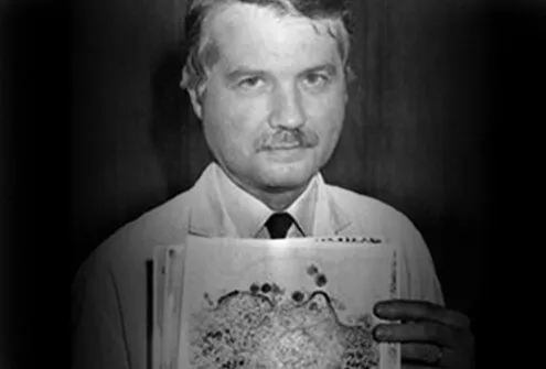 Dr. Luc Montagnier holds images of AIDS viruses.