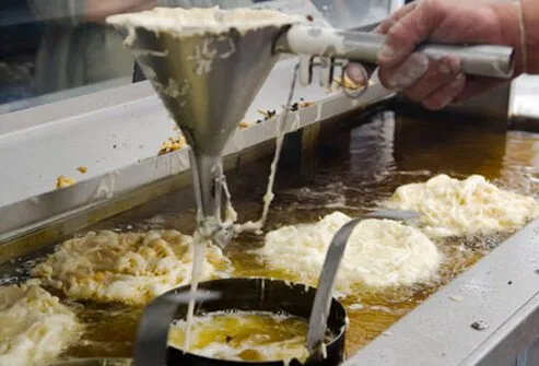 Photo of a man making funnel cakes.