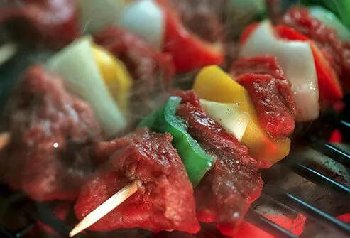 Beef and vegetable shish kebab skewers on cooking on the grill.