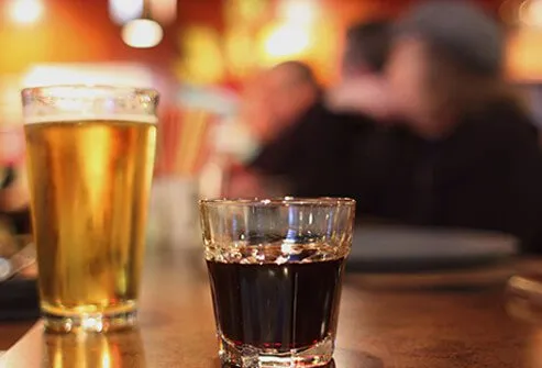 Guy mixing hard alcohol with beer.