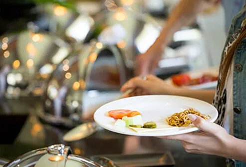 A woman chooses small portions for her plate.